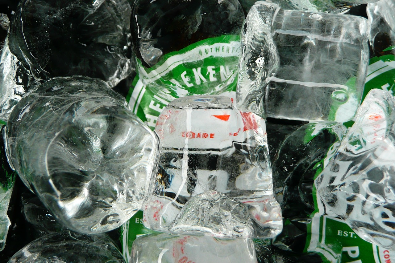 Bierflesjes onder een laag ijsblokjes